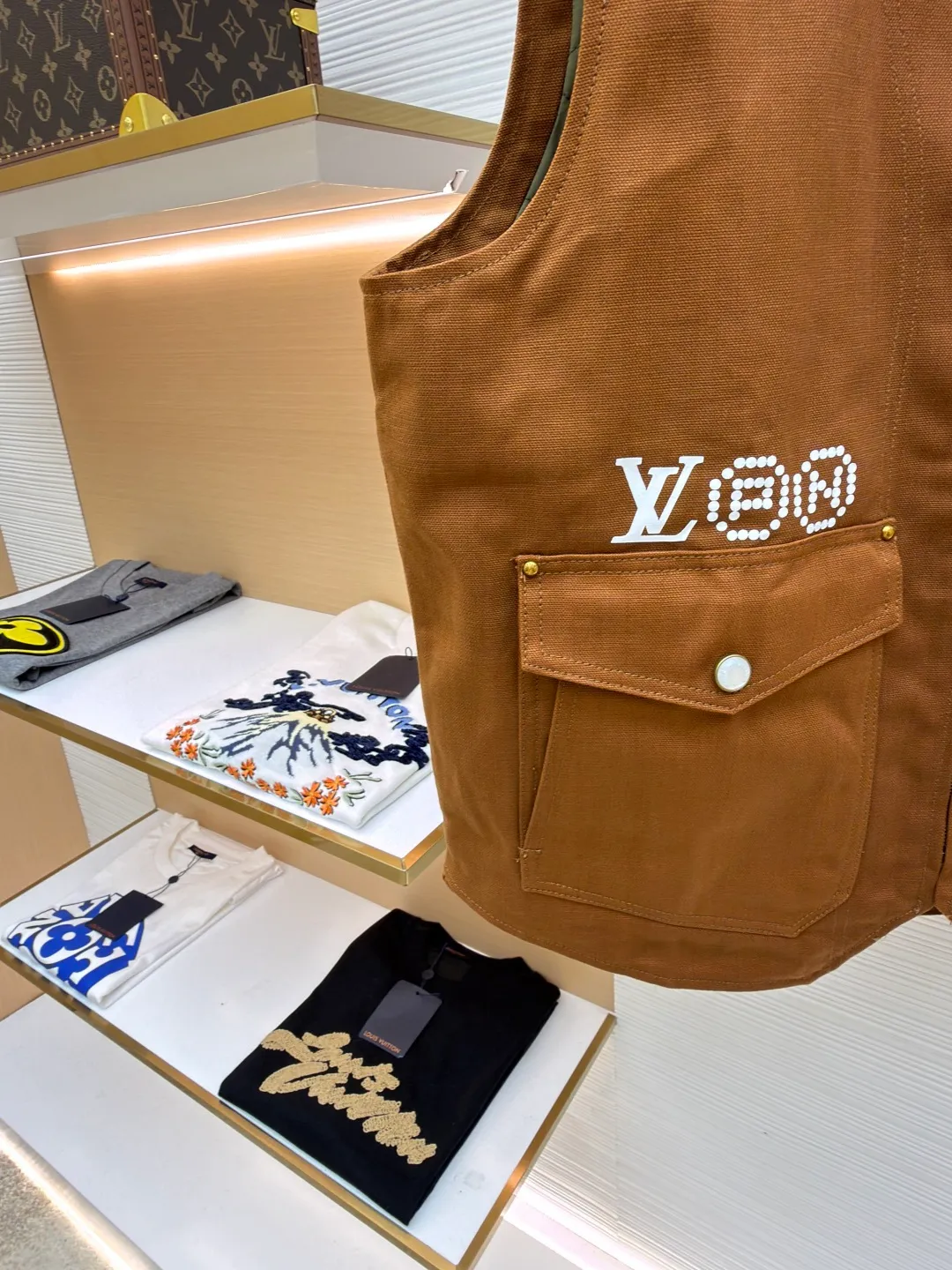 LOUIS VUITTON Nigo joint portrait work vest ●Original version: Purchased and developed for 16999 ●Item number: 1681331-B75 ●Fabric: denim fabric ●Technology: printing production ●Color: brown ●Version: fitted version ●Weight: about 785 grams ●Size: S-M-L-XL ●Description: Made of high-quality brown twill fabric, the texture is crisp and wear-resistant. The stability and texture of the fabric are ensured through fine weaving technology, which provides good support for the vest. The brand logo embroidery on the left uses a combination of bead embroidery and thread embroidery. The beads are arranged regularly, the embroidery stitches are fine, the pattern has a strong three-dimensional effect, and it is perfectly integrated with the fabric, highlighting the brand's luxurious craftsmanship. It adopts three-dimensional tailoring to fit the human body shape, making it comfortable to wear and fashionable. Double-thread reinforcement technology is used during sewing, the seams are smooth and compliant, the stitch spacing is even, and the lines are straight, reflecting the exquisite level of garment making. The buttons on the pockets are custom-made metal buttons with a smooth surface and brand details, high-quality texture and strong durability; the zipper is also customized by the brand, with the zipper puller bearing the brand logo, and the zipper is smooth and easy to pull. The quilted lining on the inside not only increases the warmth of the vest, but also improves the overall sophistication. The quilting lines are regular and reflect the meticulous craftsmanship. The design of the large pockets is both practical and decorative, with neat stitching on the edges of the pockets; the lines of the neckline and body are simple and elegant, and the overall craftsmanship details reflect the brand's high-end production standards. The overall wiring is straight and delicate, the fabric is comfortable and soft, and the color is consistent without color difference. It can be matched with the same style to create a fashionable look and control various occasions. Customized accessories, complete with three standards, same style for men and women!